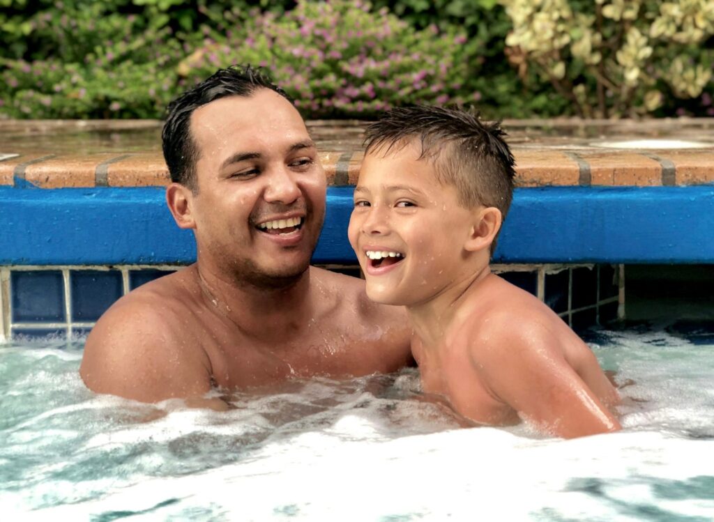 Father and son laughing in jacuzzi